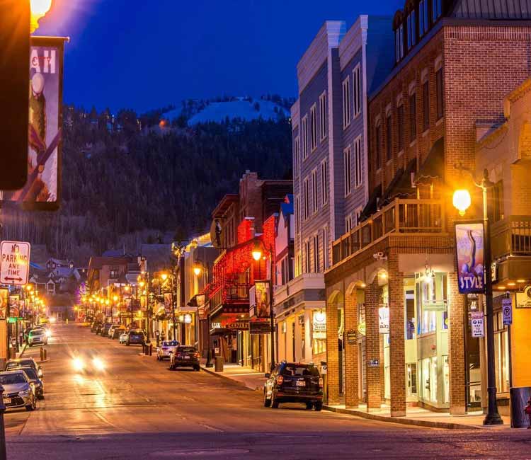 a city street with a lot of traffic with XE Park City's luxury transportation.