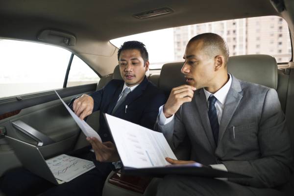 Businessman using mobile phone, ready for corporate events transportation in Salt Lake City.