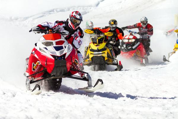 a man riding a snowboard down a snow covered slope with XE Park City's luxury transportation.