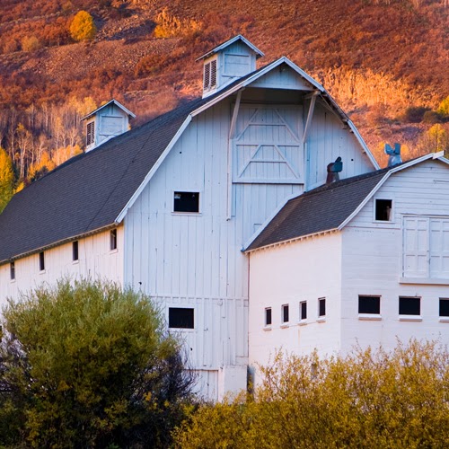 a house with a large window and a large building with XE Park City's luxury transportation.
