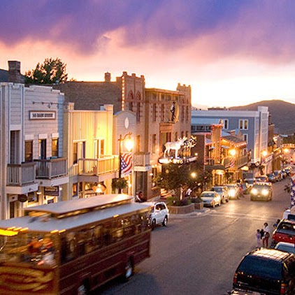 a city street with cars and buses driving down it with XE Park City's luxury transportation.
