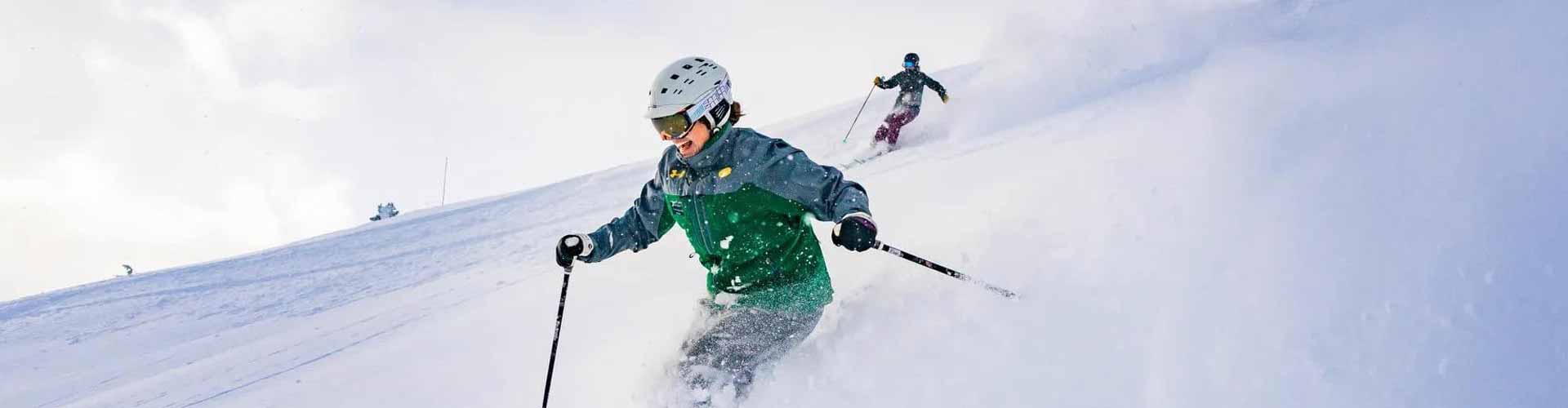 a skier is going down a hill on a sunny day with XE Park City's luxury transportation.